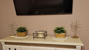 A white dresser with black handles, two gold decorative boxes, and two small potted plants. - Cozy Dream Cottage (Colorado Springs)