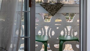 A view from a balcony with a table and two chairs, overlooking a large building with classical architecture. - Views of Palace of the Parliament 3BR Safari Design (Bucharest)