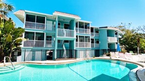 Un hôtel à plusieurs étages doté de balcons, d’une piscine et situé dans un cadre tropical.