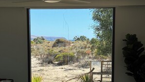 A ping pong table with a view of a desert landscape through a large window. - Normanville Beach House - Wake up to the sound of the ocean and bird life. (Normanville)