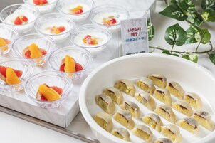 Diversos postres, incluyendo pequeños vasos con fruta y un tazón más grande con rebanadas de pastel.