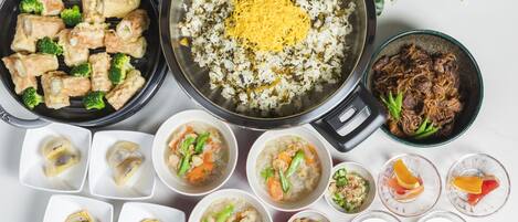 A variety of dishes including fried chicken, rice with vegetables, and soup.