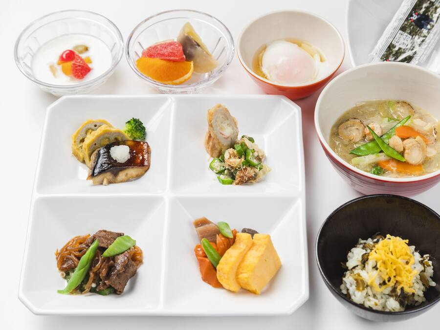 Variedad de platos japoneses, incluyendo sushi, sashimi y un tazón de sopa.