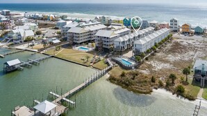 Oversigtsbillede af et kysthotel med flere bygninger, en lysthavn og en strand.