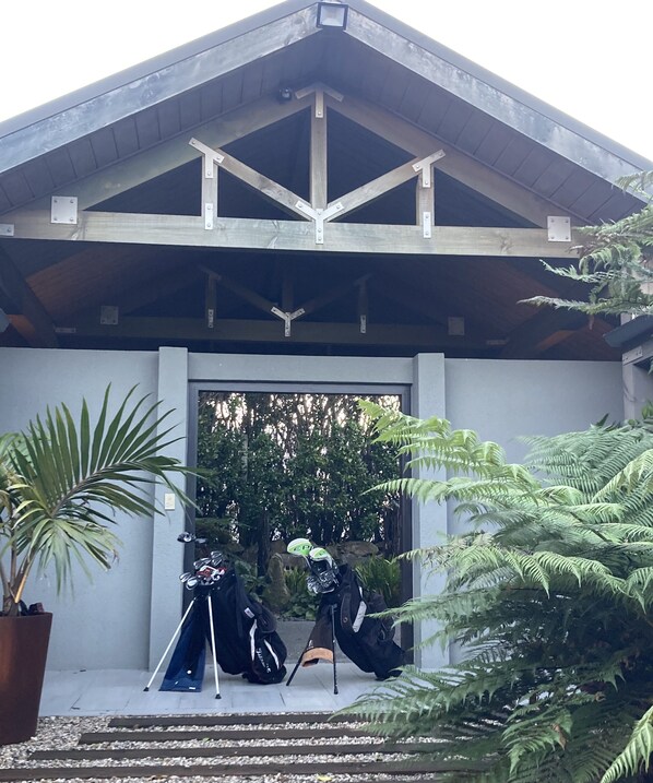A covered entrance with a wooden roof and a potted plant to the left.