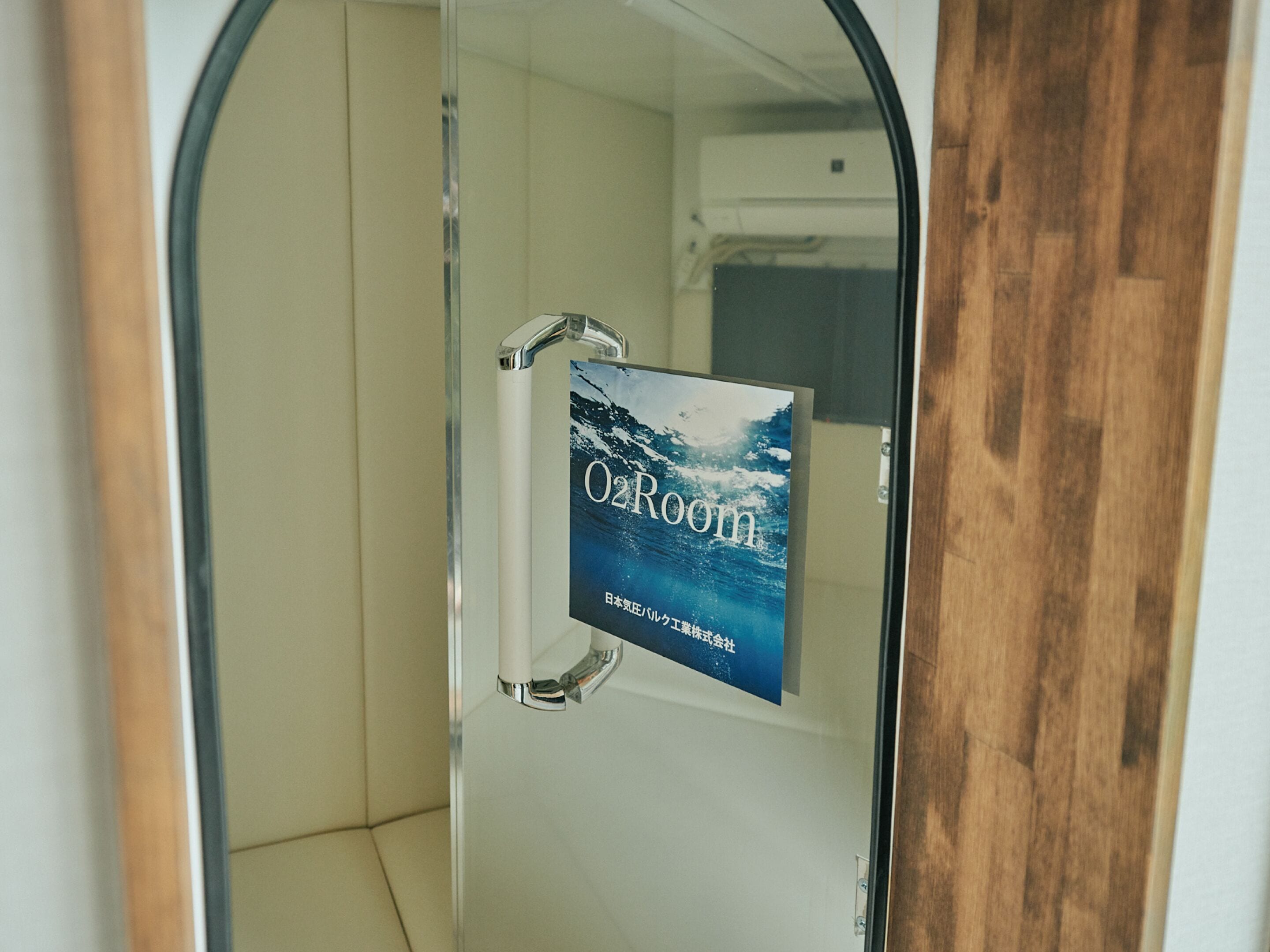 A glass door with a sign reading "O2Room" and a view of a bathroom with a white bathtub and a shower area.