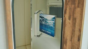 A glass door with a sign reading "O2Room" and a view of a bathroom with a white bathtub and a shower area.