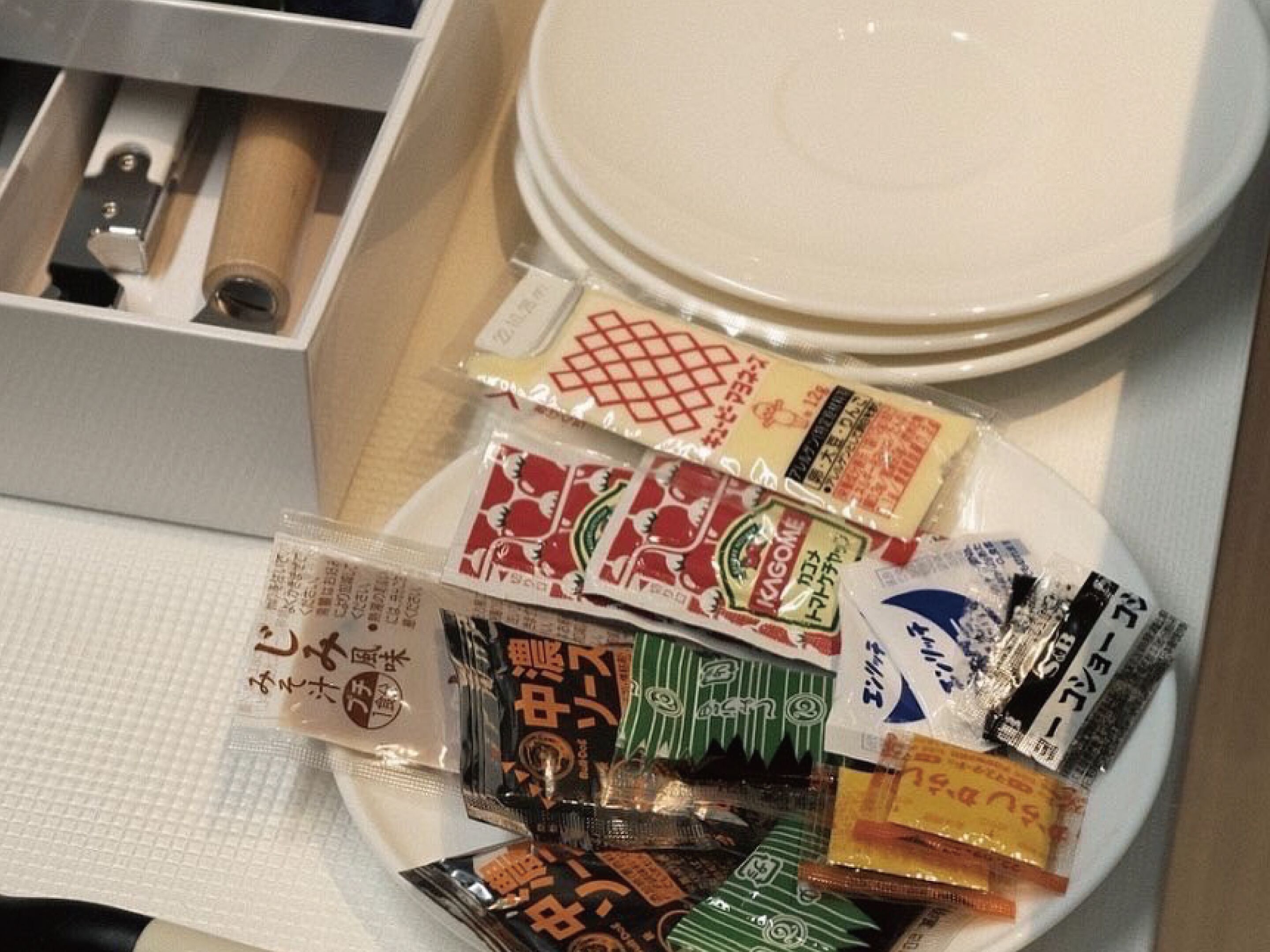 A plate with various packaged snacks and a set of chopsticks.