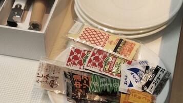 A plate with various packaged snacks and a set of chopsticks.