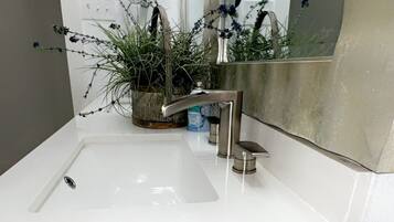 A bathroom with a white sink, a mirror, and a towel rack.
