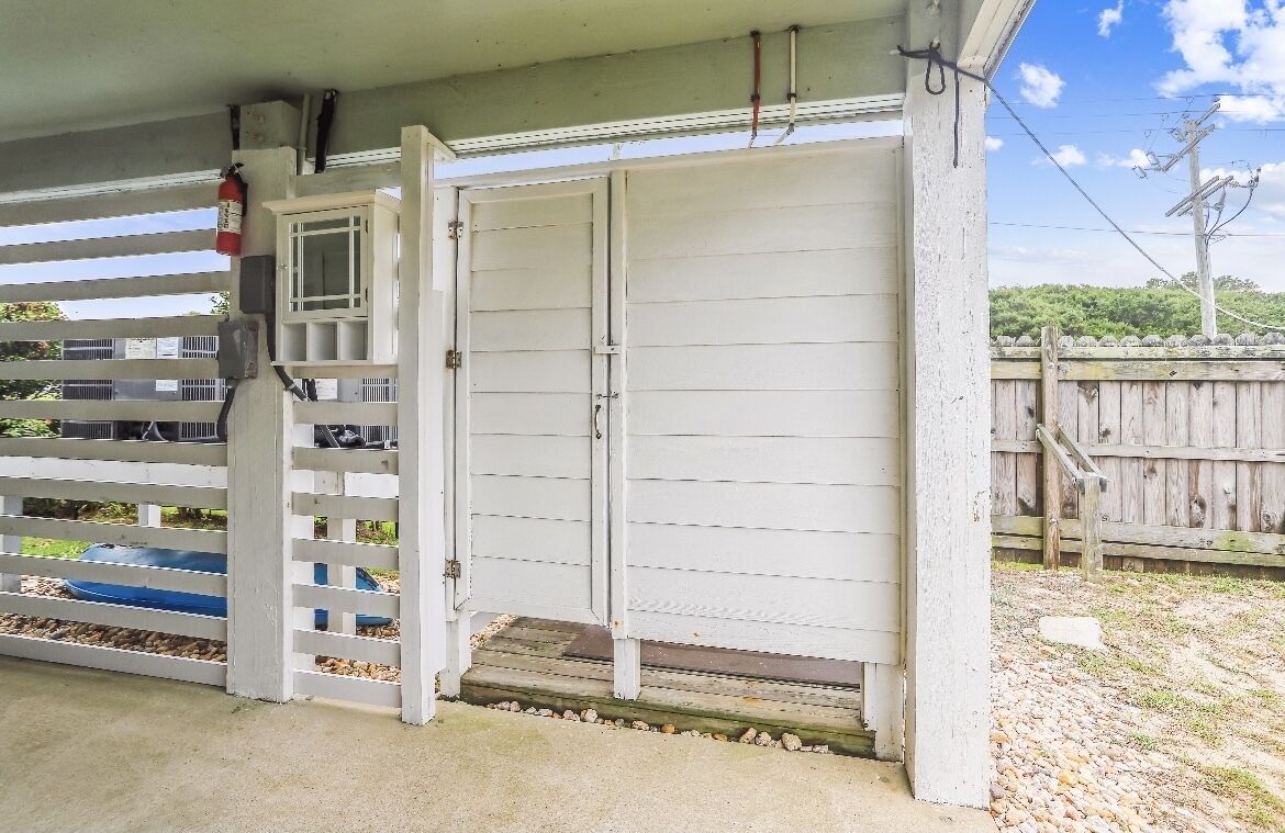 Eine weiße Garagentür mit kleinem Fenster und einem an der Wand befestigten Feuerlöscher.