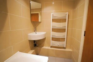 A bathroom with a white sink, a mirror, and a towel rack. - Lovely 2-Bed Apartment in London (London)