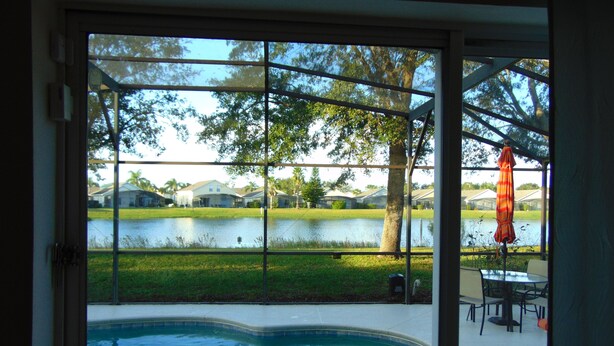 A swimming pool with a view of a lake and houses in the background.