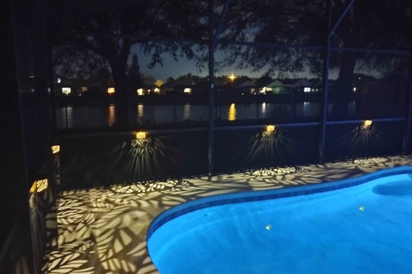 Lights reflecting off the lake poolside at night.