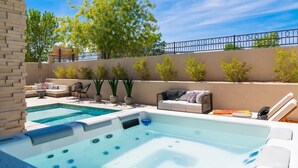 Piscina com hidromassagem, área de estar ao ar livre e vista do céu.