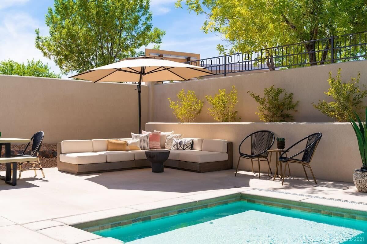 A poolside area with a seating arrangement, including a sofa and chairs, and a small table.
