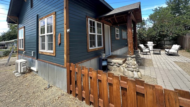 Une maison à deux étages, avec une façade d’un bleu foncé, des éléments décoratifs en bois et des fondations en pierre.