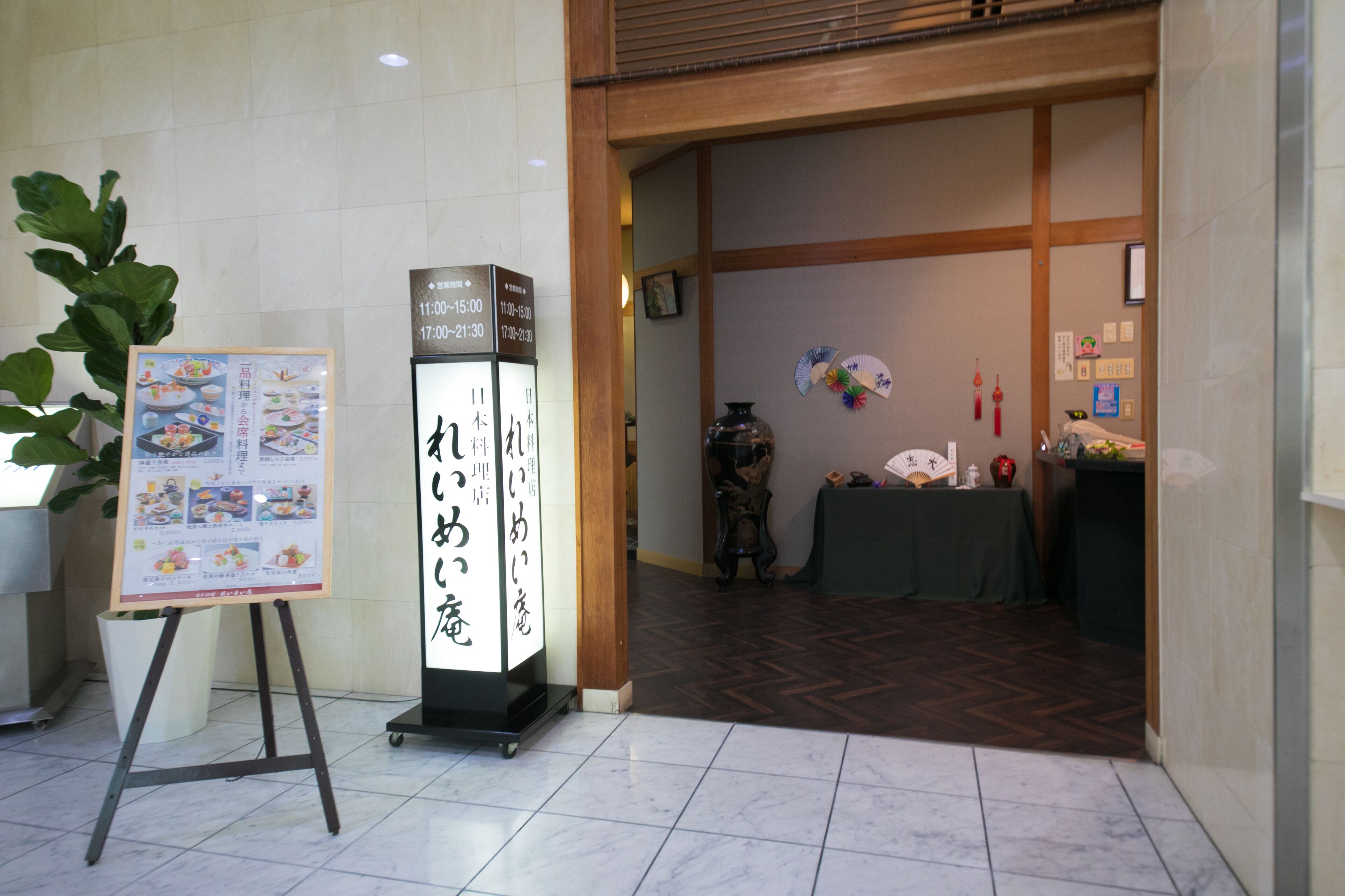 Zona de recepción con un letrero, una planta en maceta y una decoración interior tradicional japonesa.