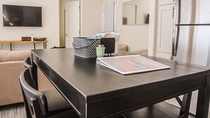 A modern kitchen with a dark countertop, a refrigerator, and a dining area. - NEW!  THE RETREAT Ranch House - Only 20 minutes from the Grand Canyon (Williams)