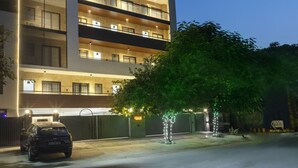A multi-story building with balconies, a gated entrance, and a parked car. - Perch Service Apartments DLF Cyber City (Gurugram)