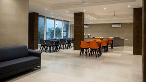A modern hotel lobby with a seating area, a sofa, and a reception desk. - Perch Service Apartments DLF Cyber City (Gurugram)