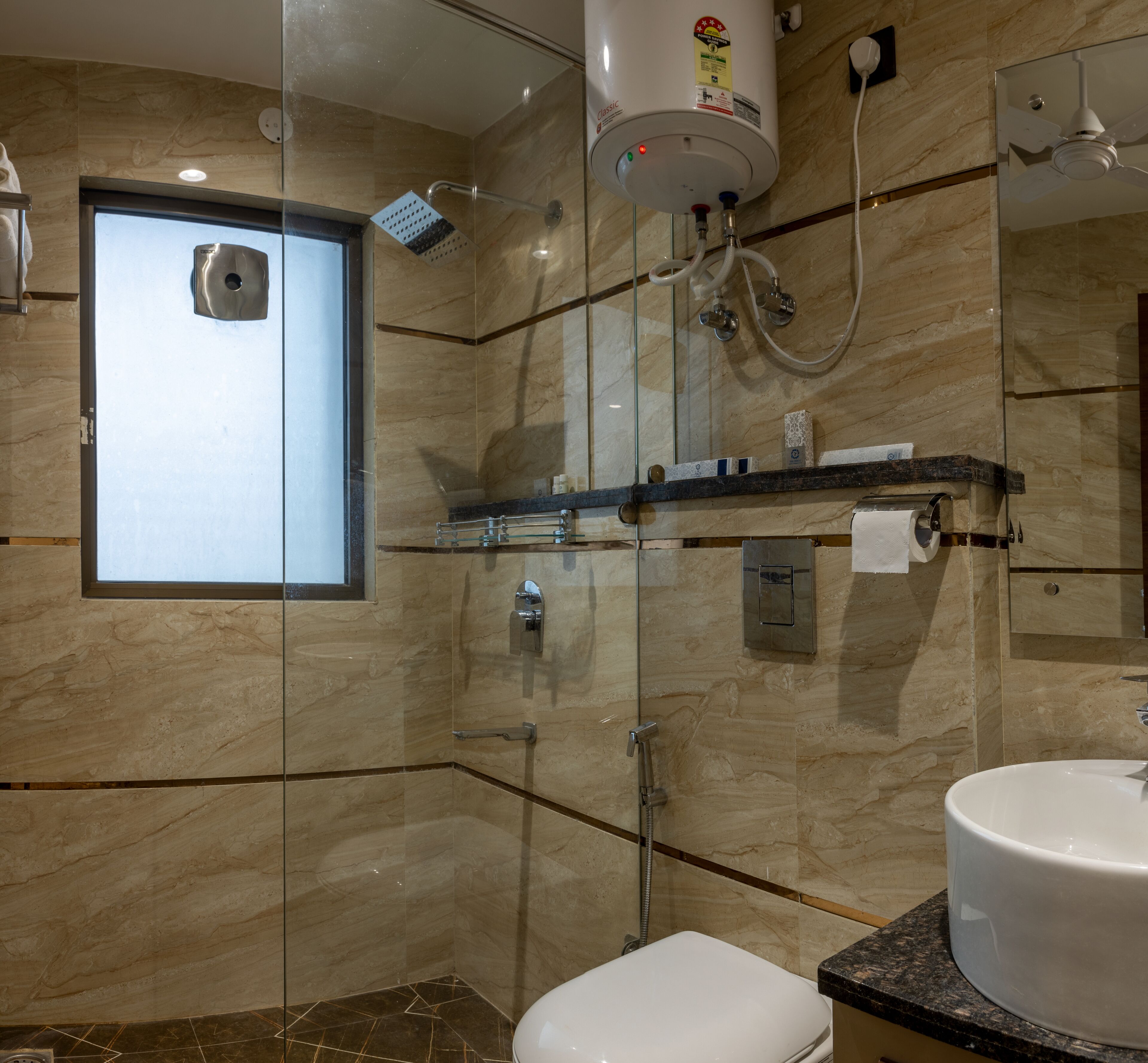 A modern bathroom with a glass-enclosed shower, a built-in toilet, a vanity with a sink, and a window providing natural light.
