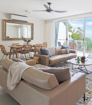 Relax in this spacious living room with a comfortable sofa, armchair, and dining area.