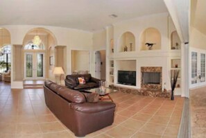 Cozy living area with a large sofa, fireplace, and flat-screen TV.