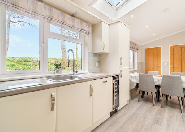A modern kitchen with a window, sink, and dining area.