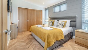 Una camera da letto moderna con un letto, un'armadio in legno e una televisione.