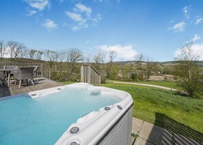 A hot tub on a wooden deck with a view of a grassy area and trees. - Caburn View Retreat (Pet) (Lewes)