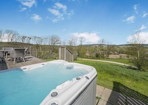A hot tub on a wooden deck with a view of a grassy area and trees. - Caburn View Retreat (Pet) (Lewes)
