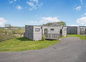 A row of mobile homes with a paved driveway and grassy areas. - Caburn View Retreat (Pet) (Lewes)