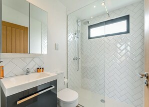 Un baño moderno con ducha, inodoro y lavabo.