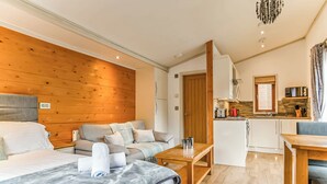 Une chambre d’hôtel de taille réduite, comprenant un lit, un canapé et une kitchenette.