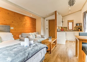 Quarto de hotel compacto com cama, sofá e cozinha compacta.