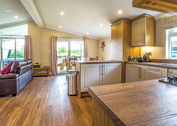 Eine moderne Küche mit Holzschränken, ein Essbereich mit Tisch und Stühlen sowie eine Ledersofa.