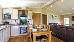 A compact kitchen with a dining area, a sofa, and a TV. - Lakeview 2 Pet Friendly (Woodhall Spa)