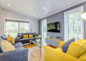 A living room with a sofa, coffee table, and TV. - 1 bedroom accommodation in Haddon (Haddon)