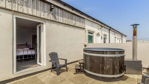 A room with a bed, a chair, a hot tub, and a window. - 1 bedroom accommodation in Crimdon (Crimdon)