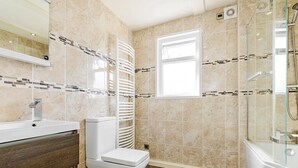 A modern bathroom with a toilet, sink, and shower area.