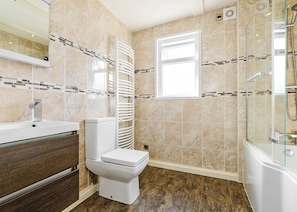 A modern bathroom with a toilet, sink, and shower area.