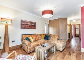 A modern living room with a sectional sofa, a wooden coffee table, and a floor lamp. - 3 bedroom accommodation in Flaxton (Flaxton)