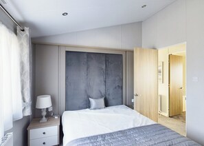 A bedroom with a bed, bedside table, lamp, and a wardrobe. - Brand new for 2021 a complete home from home with 2 double bedrooms. (Skegness)