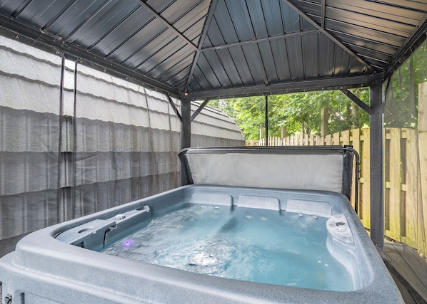 A hot tub under a covered area with a wooden fence in the background. - Here at Riverview our hot tub pods have been warming up. (Newcastleton,)