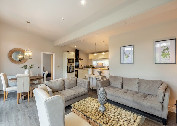 A modern living room with a sofa, coffee table, and dining area.