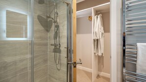 Une salle de bain moderne avec une douche à parois de verre, un porte-serviettes et des toilettes.