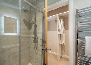 Une salle de bain moderne avec une douche à parois de verre, un porte-serviettes et des toilettes.