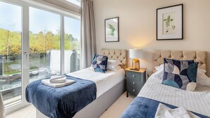 Une chambre d’hôtel avec deux lits, une grande fenêtre et une vue sur un plan d’eau.
