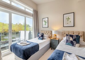 Une chambre d’hôtel avec deux lits, une grande fenêtre et une vue sur un plan d’eau.
